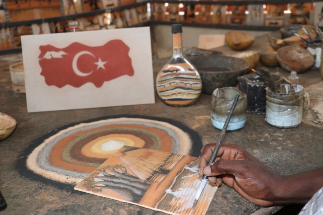 Köle adasının tarihini rengarenk kumlarla tablolara yansıtıyor